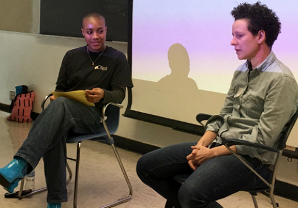 a man and a woman talking in front of a classroom