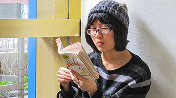 woman sitting in a windwo reading a book