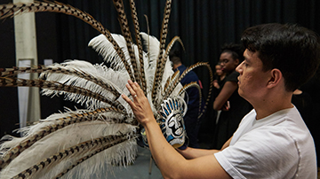 man arranging feathers on a head dress