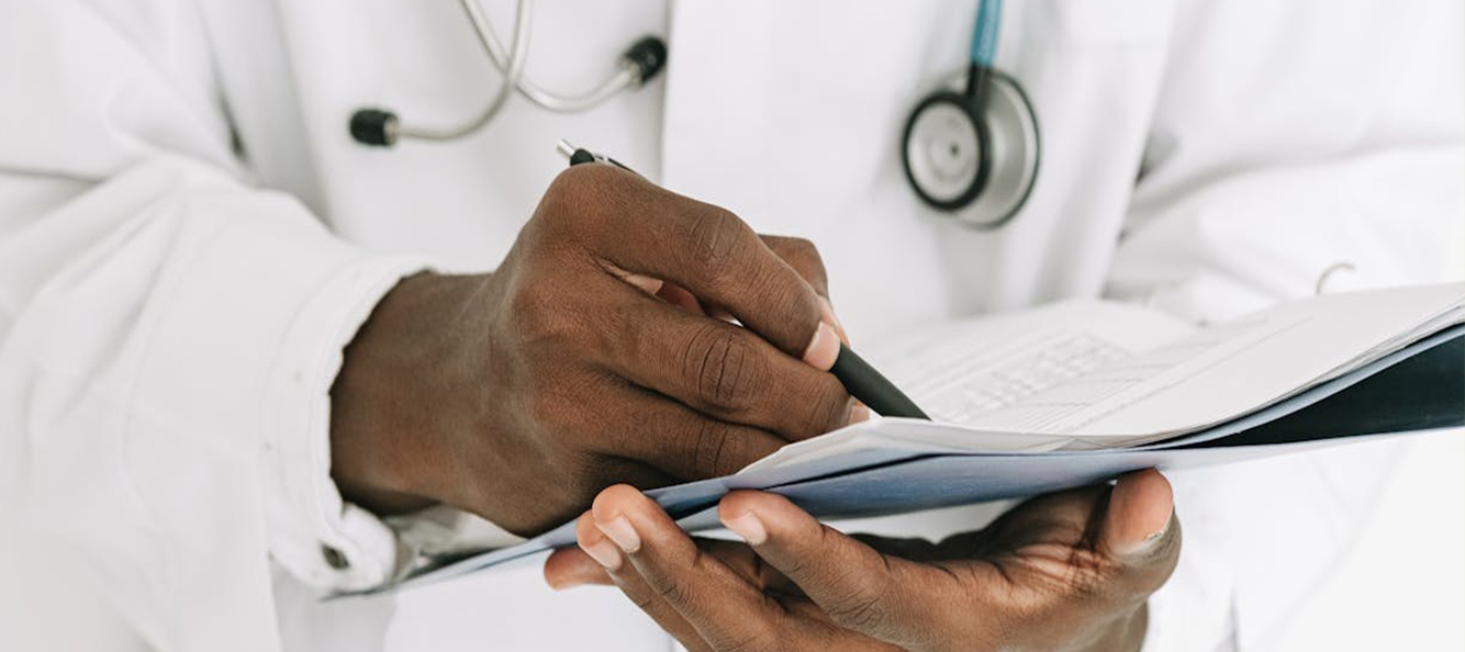 Hands of a care provider holding a case file and pen