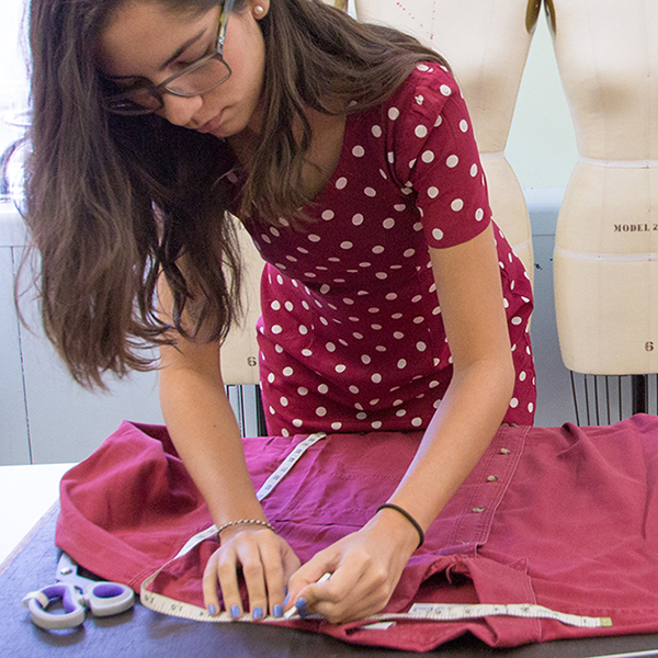 student measuring a shirt