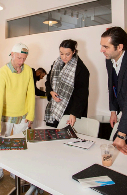 attendees discuss posters laid out on a table