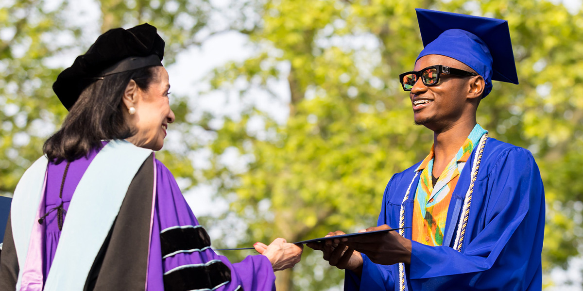 FIT President Dr. Joyce F. Brown hands diploma to graduate