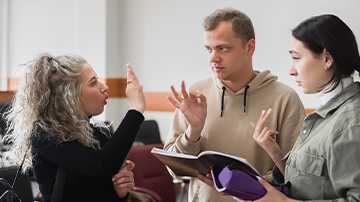 three students communicating using sign language