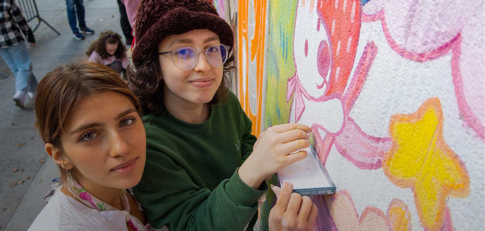 Two FIT students working on murals outdoors on campus for ChalkFIT