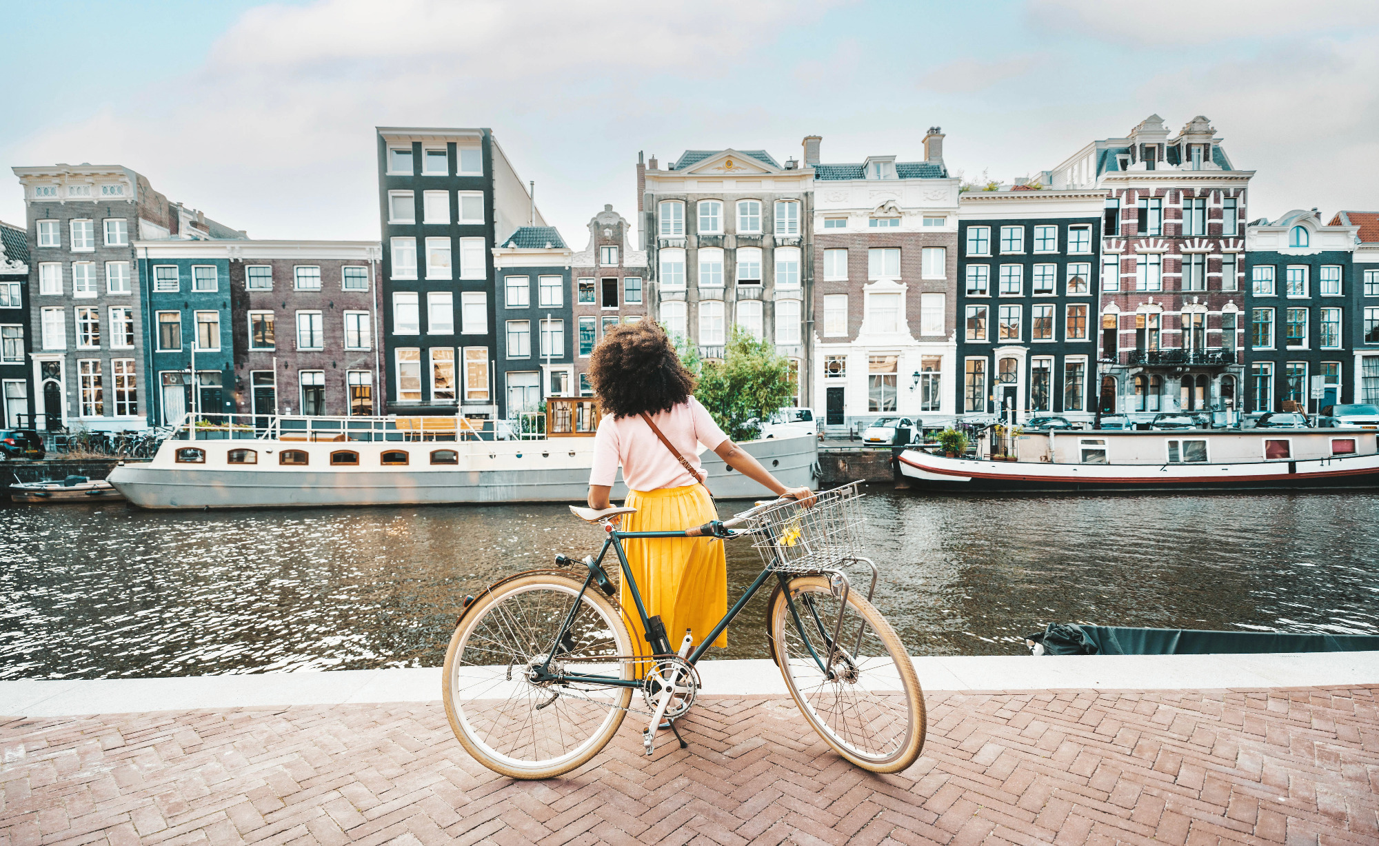 girl with bike looks out over Amsterdam canal