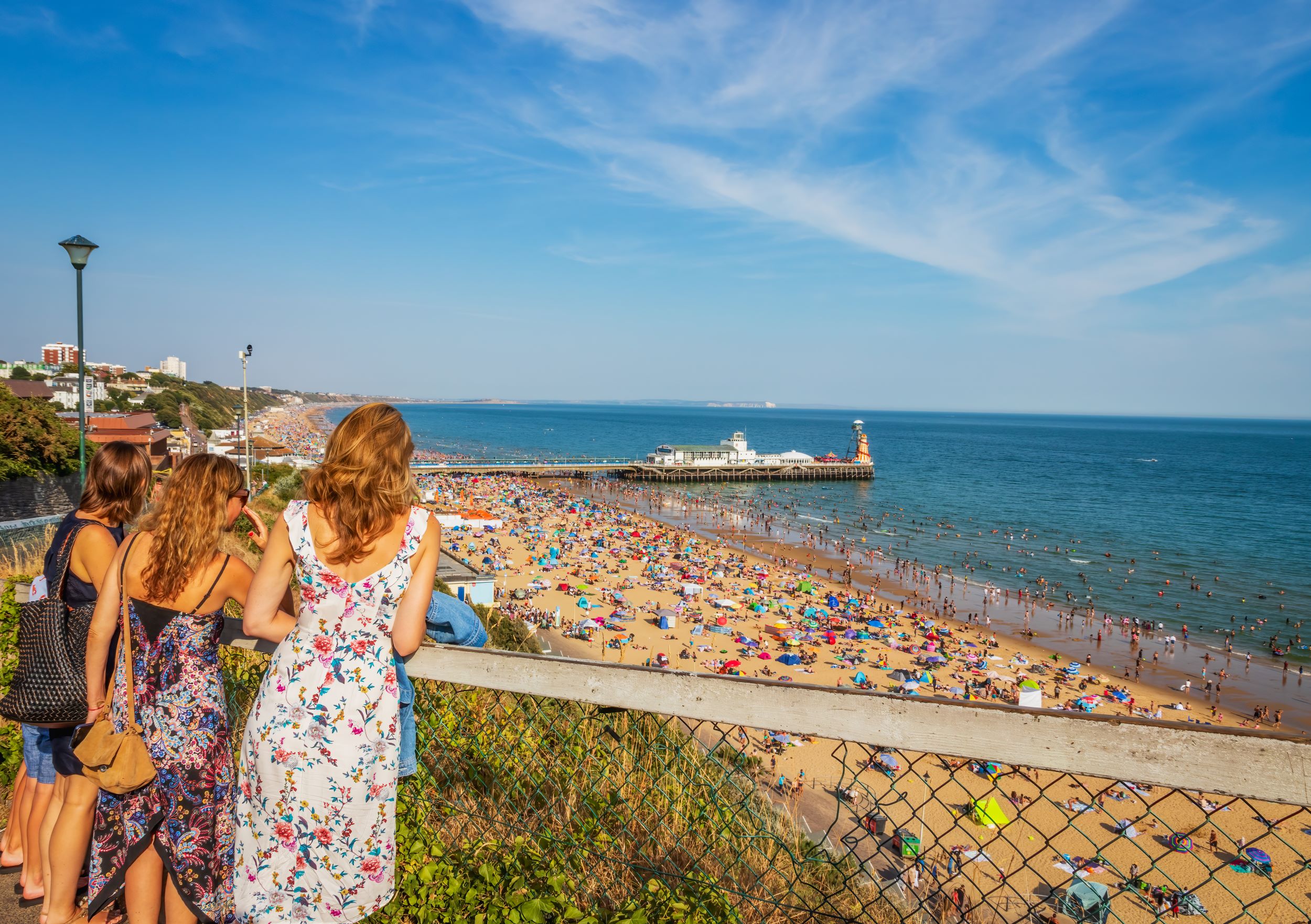 Girls looking towards Bournemouth Beach and Pier in Dorset England UK