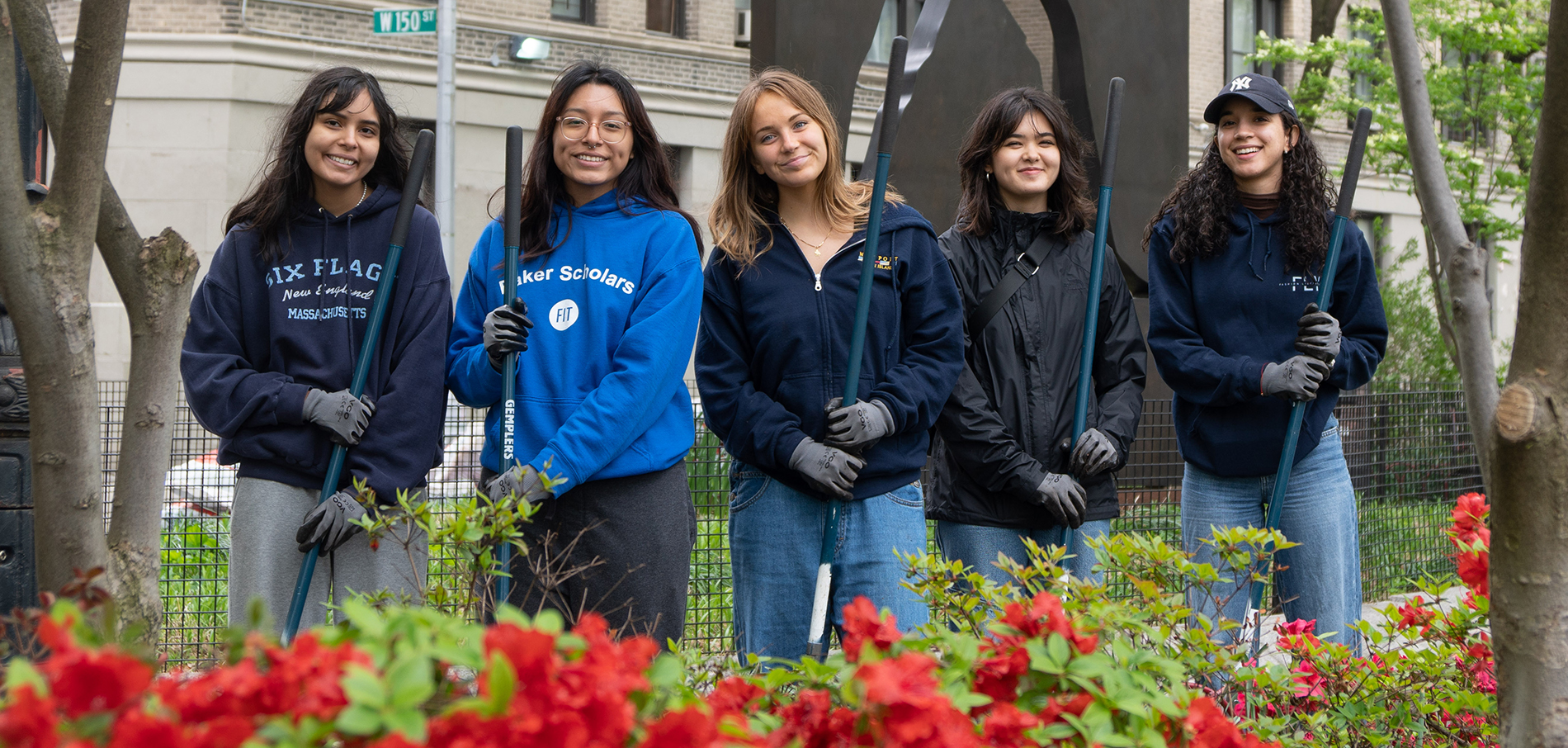 FIT students working together in park holding garden tools