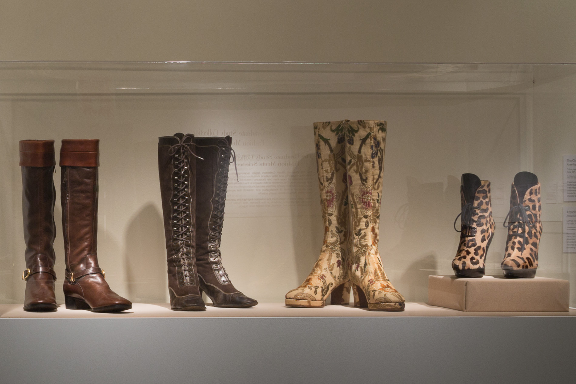  four pairs of high boots of different patterns in a glass encasement