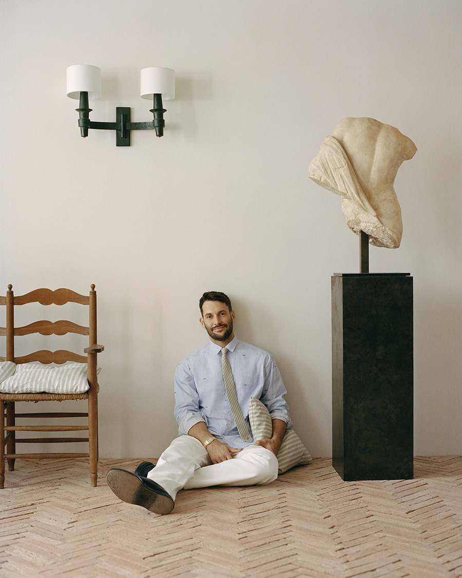 Jacquemus sitting on the floor of a room with his back against the wall