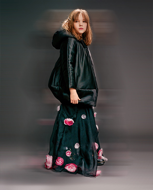 young child wearing black jacket and skirt with rose details