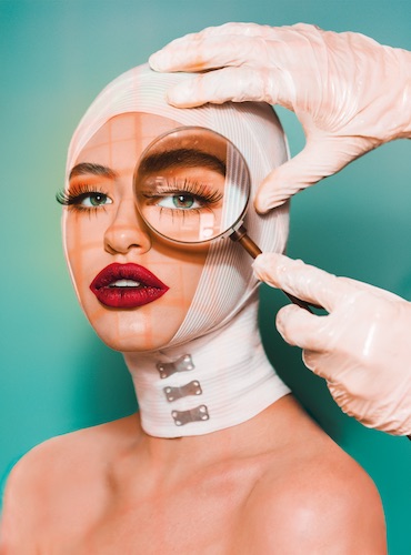 editorial style photo of women with magnifying glass held up to face