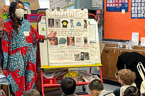 instructor showing a room of young stundents various clothing types
