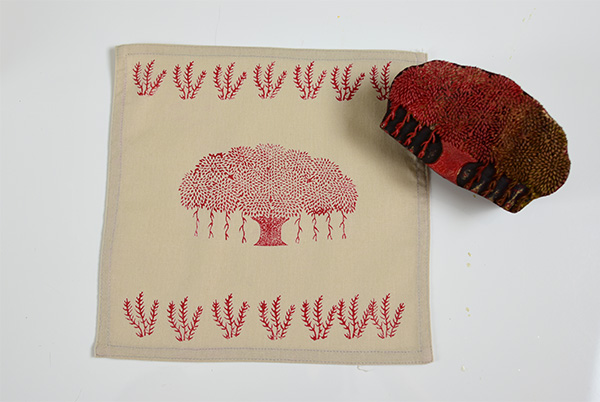 wooden printing block design of tree coated in red paint