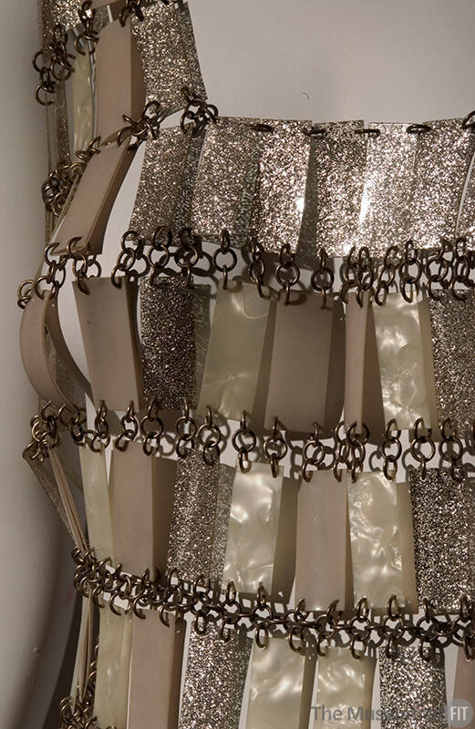 a dress composed of shimmering beige, cream, and gold rectangles chained together