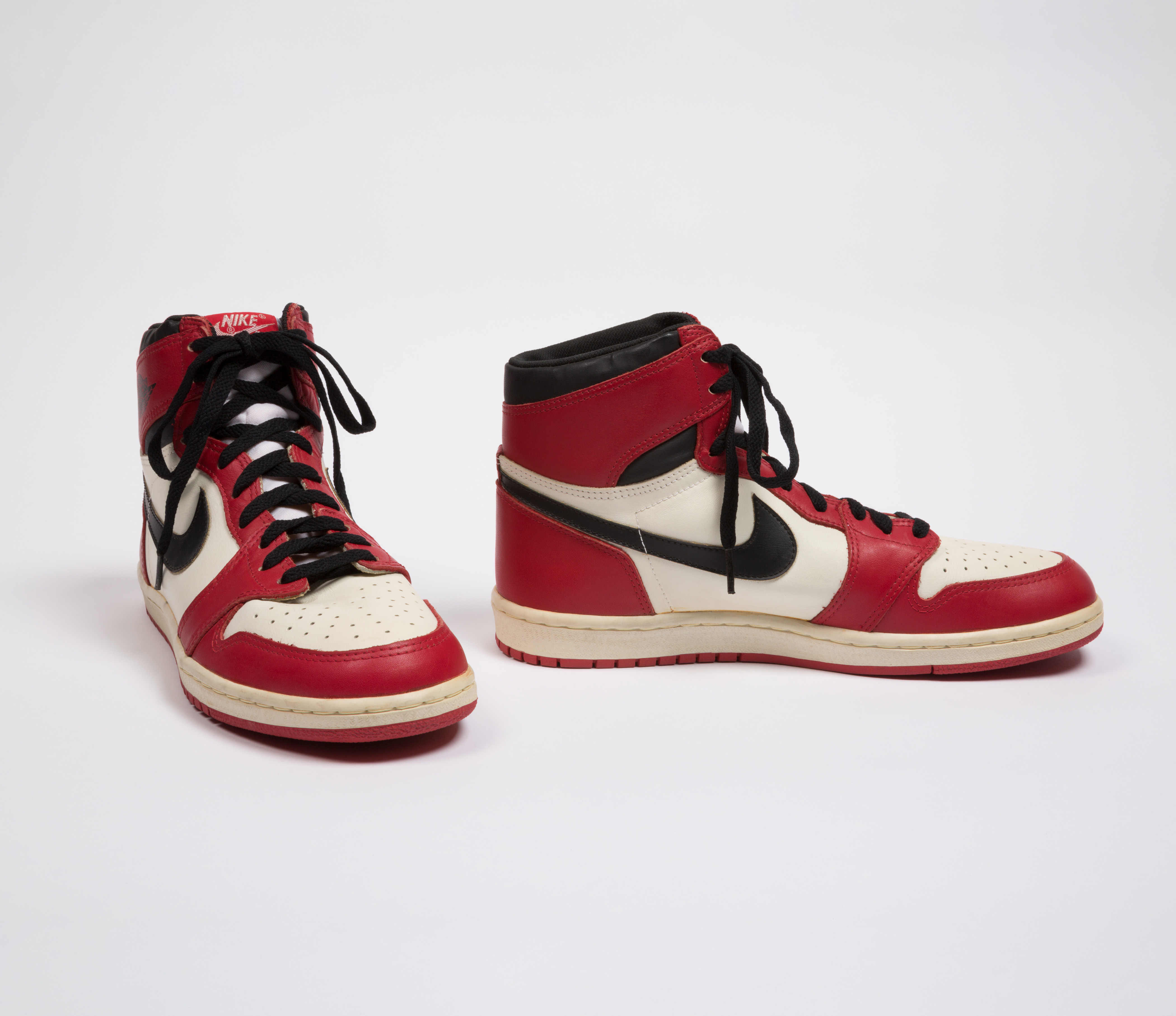 red and white high top sneakers with black nike swoosh