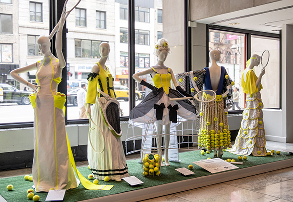 5 mannequins featuring dress designs with tennis balls and racquets