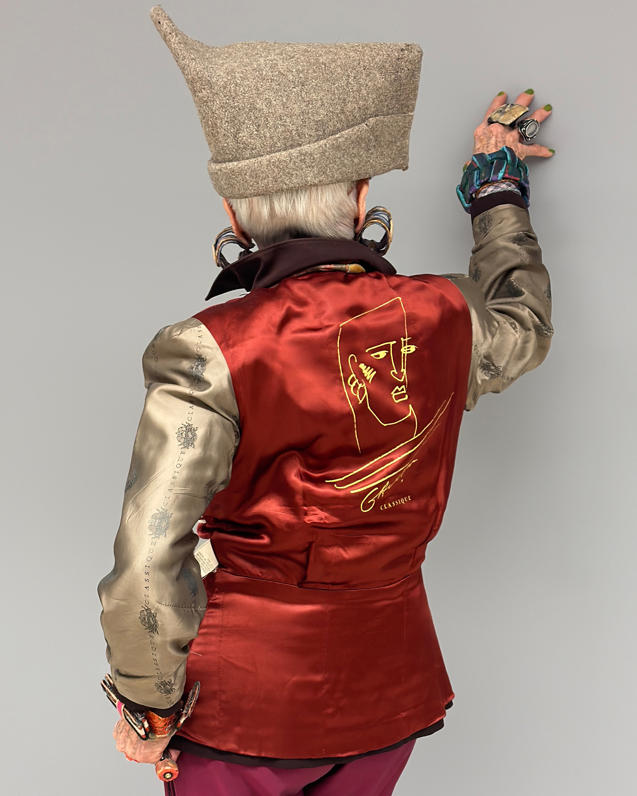 Back view of Debra's outfit, showcasing an illustration of a portrait, embroidered in yellow thread