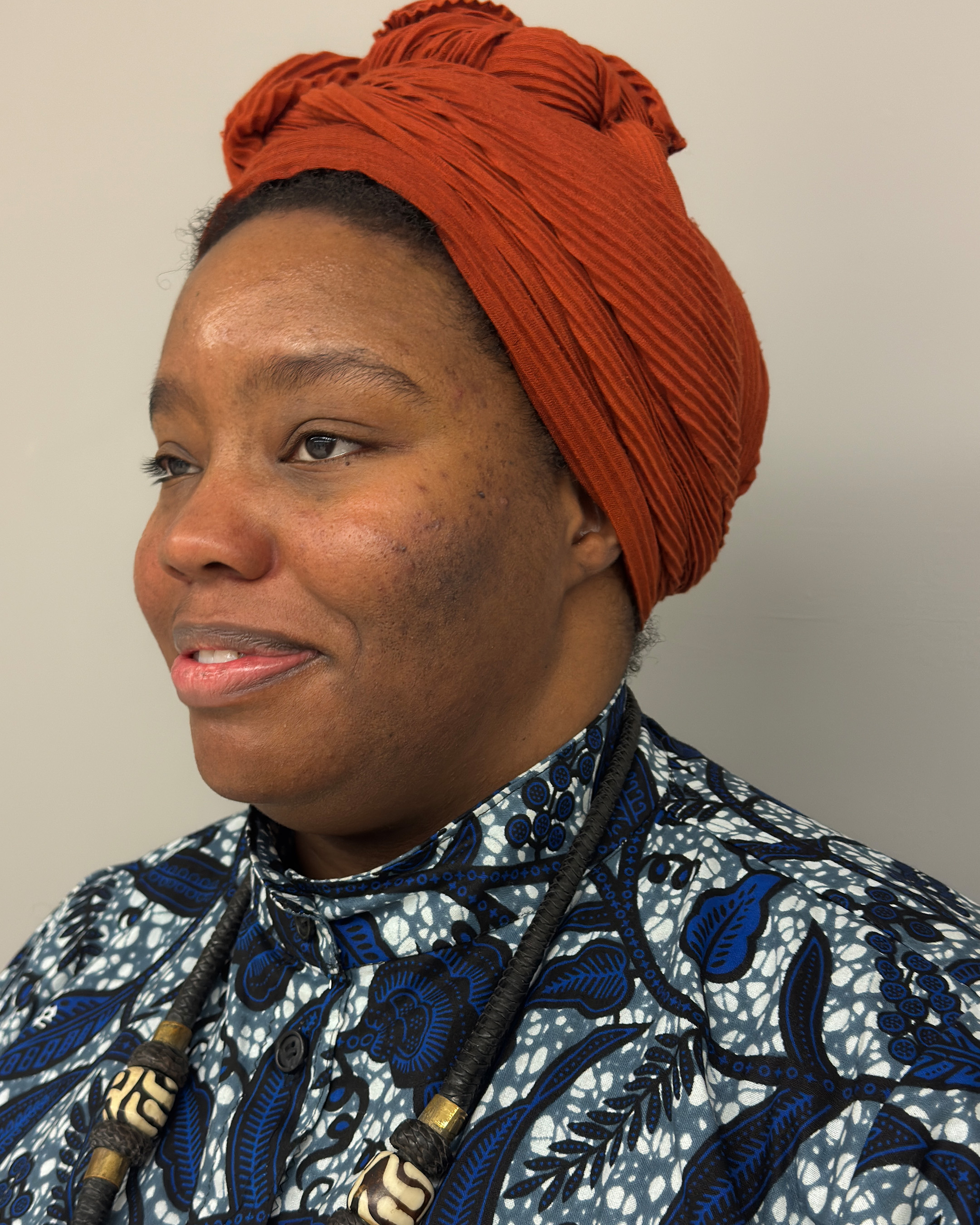 Cheyney's side profile, featuring her rust colored head wrap