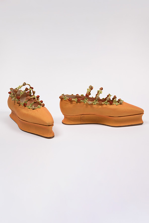 orange yellow flats with sculptured, platform sole and four narrow instrep straps with red ribbon rosebuds and leaves