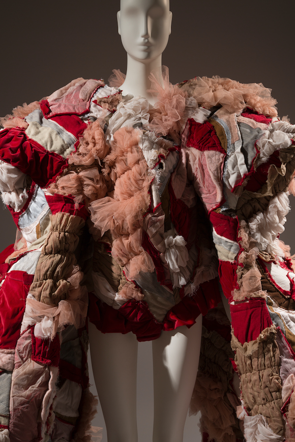 mannequin wearing body suit with a quilted robe in shades of pink and red 