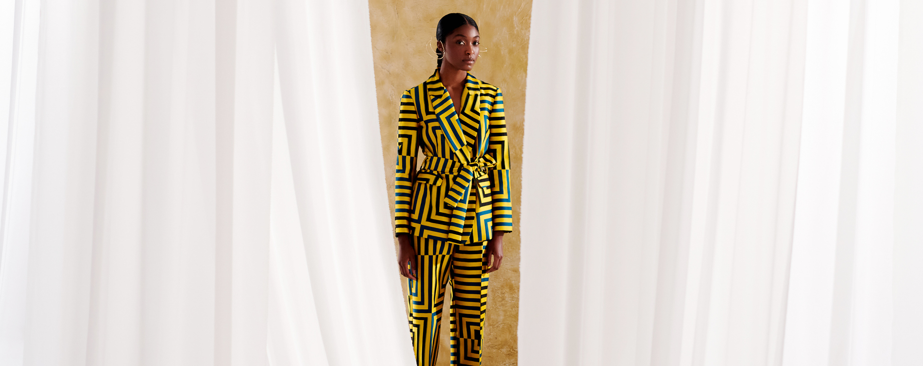 woman wearing striped yellow and blue-green ensemble 