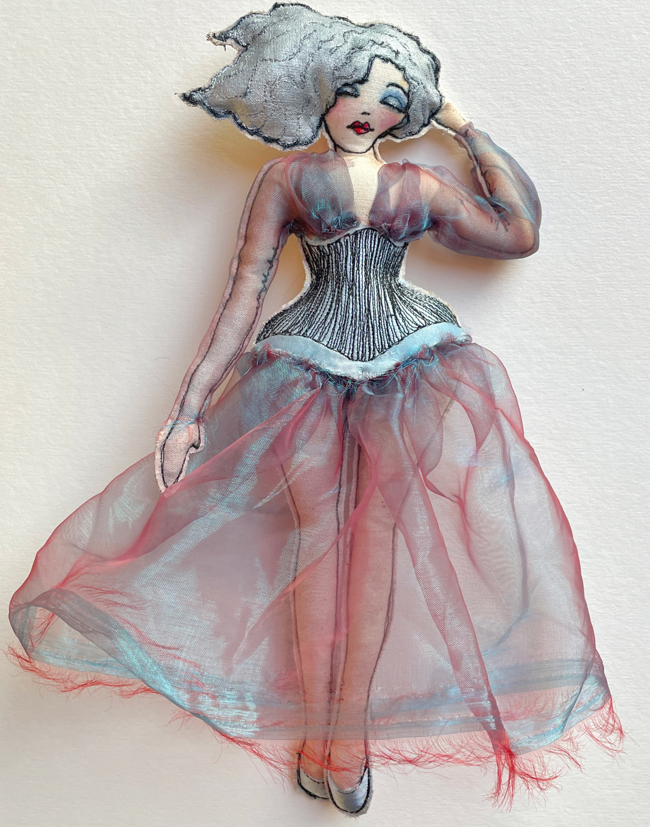 full figured felt doll with watercolor and acrylic painted face with iridescent dress and a black corset 